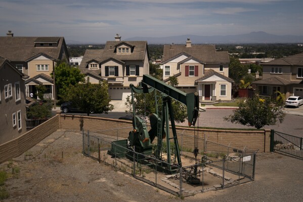 FILE - A pump jack extracts oil at a drilling site next to homes June 9, 2021, in Signal Hill, Calif. Environmental advocates in California will try to enshrine a law banning new gas and oil wells near homes, schools and hospitals in a move that comes as the oil industry is vying for voters to overturn it. (AP Photo/Jae C. Hong, File)