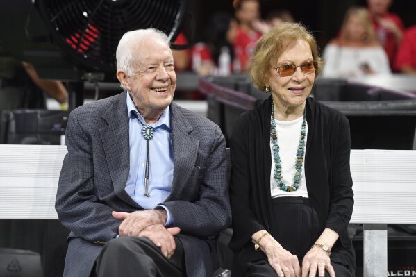 FILE- In this Sept. 30, 2018 file photo, former President Jimmy Carter and Rosalynn Carter are seen ahead of an NFL football game between the Atlanta Falcons and the Cincinnati Bengals, in Atlanta.  Former President Jimmy Carter and former first lady Rosalynn Carter will not attend President-elect Joe Biden’s inauguration. It marks the first time the couple, 96 and 93, will have missed the ceremonies since Carter was sworn-in as the 39th president in 1977.(AP Photo/John Amis, File)