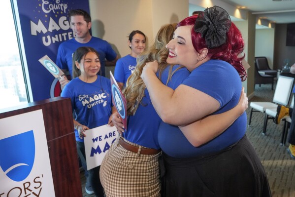 Disneyland Resort Cast Members, Courtney Griffith, left, hugs Angela Nichols after a news conference in Anaheim, Calif., Wednesday, April 17, 2024. Workers who help bring Disneyland's beloved characters to life said Wednesday they collected enough signatures to support their push for a union. (AP Photo/Damian Dovarganes)