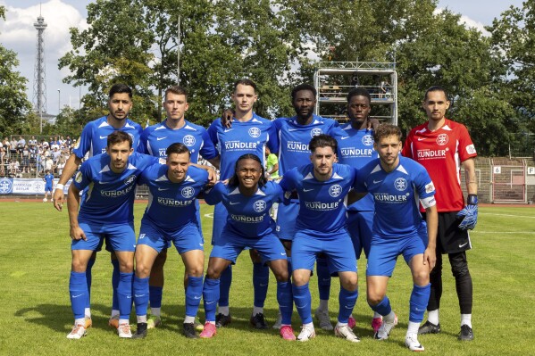 The Makkabi Berlin team pose for a group photo before its German Cup first-round game against visiting Wolfsburg, in Berlin, Sunday, Aug. 13, 2023. Makkabi, which was founded by Holocaust survivors in 1970, had already made history just by qualifying for the 64-team German Cup – by winning the Berlin Cup for the first time – to become the first Jewish club to take part since the tournament was started under the Nazis in 1935. (AP Photo/Ciaran Fahey)