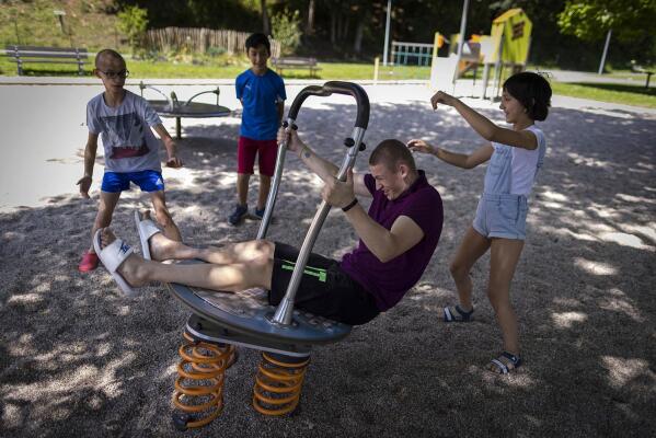 Maksim, left, Eduardo, Timofey, front center, and Varvara, right, play in a park in Loue, western France, Saturday, July 2, 2022. An Associated Press investigation has found that Russia’s strategy to take Ukrainian orphans and bring them up as Russian is well underway. After two months of negotiation and an initial objection from a senior Russian official, DPR authorities finally agreed to allow a volunteer with power of attorney from their mother to collect them. (AP Photo/Jeremias Gonzalez)
