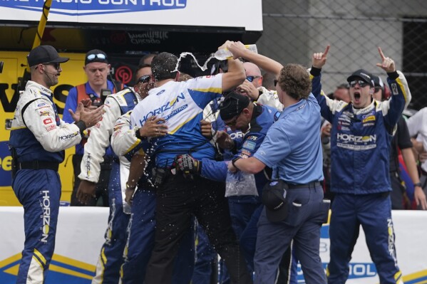 The crew of Michael McDowell celebrates after McDowell won the NASCAR Cup Series auto race at Indianapolis Motor Speedway, Sunday, Aug. 13, 2023, in Indianapolis. (AP Photo/Darron Cummings)
