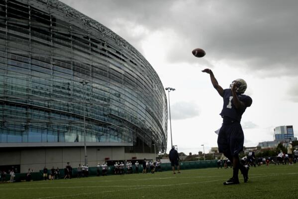 FILE - Navy quarterback Trey Miller during a training session at the Aviva Stadium, Dublin, Ireland, Aug. 30, 2012.  College football is going international again with Nebraska facing Northwestern in Dublin on Saturday Aug. 27, 2022. It's the first regular-season international game in five years. (AP Photo/Peter Morrison, File)