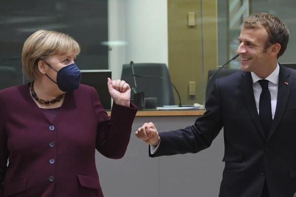 France's President Emmanuel Macron, right, talks to Germany's Chancellor Angela Merkel during a round table meeting at an EU summit in Brussels, Friday, Oct. 22, 2021. European Union leaders conclude a two-day summit on Friday in which they discussed issues such as climate change, the energy crisis, COVID-19 developments and migration. (John Thys, Pool Photo via AP)