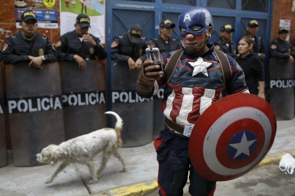 In this Thursday, May 25, 2017, a clown dressed as comic book character Captain America chats with a friend as he takes part in a march celebrating Peruvian Clown Day in Lima, Peru. Hundreds ofÊprofessionalÊclowns gather annually on this date to honor the late and beloved "Tony Perejil", who died on May 25, 1987,Êafter spendingÊyears bed-ridden in a hospital. He was known as the Clown of the Poor because he would perform in impoverished neighborhoods to which he would donate a portion of his proceeds to improve the communitiesÕ infrastructures. (AP Photo/Martin Mejia)