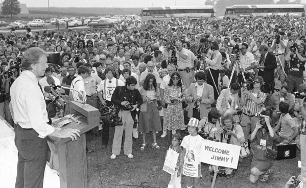 FILE - Jimmy Carter, Democratic presidential candidate, left, speaks to a crowd of supporters on the Van Ryswyk farm in Des Moines, Iowa, Aug. 24, 1976. The once-every-four-years Iowa caucuses grew to be an entrenched part of U.S. politics, catapulting little-known one-time peanut farmer Carter's bid for the White House. (AP Photo, File)