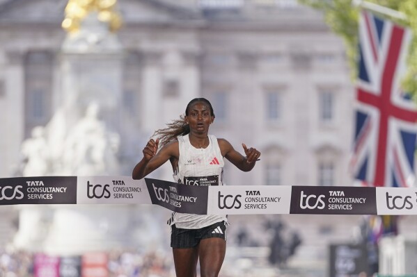 Tigst Assefa crosses the line to win the women's race at the London Marathon, Sunday, April 27, 2025. (AP Photo/Alberto Pezzali)