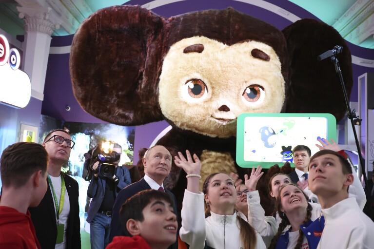 FILE - Russian President Vladimir Putin, center, accompanied by members of the Movement of the First All-Russian children's and youth organization, visits the Russia Expo international exhibition in Moscow, Russia, Thursday, Feb. 1, 2024. As Putin heads for another six-year term as Russia’s president, there’s little electoral drama in the race. What he does after he crosses the finish line, however, is what’s drawing attention and, for many observers, provoking anxiety. (Alexander Kazakov, Sputnik, Kremlin Pool Photo via AP, File)