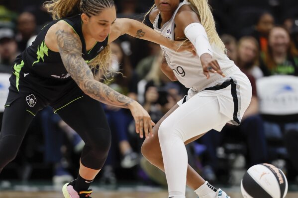 Las Vegas Aces guard Tiffany Mitchell, right, tries to steal the ball from Seattle Storm forward Gabby Williams, left, during the second quarter of a WNBA basketball game Sunday, June 1, 2025, in Seattle. (Jennifer Buchanan/The Seattle Times via AP)