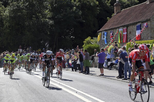 Tour De France riders cycle through the village of West Tanfield, England during the first stage of the race Saturday, July 5, 2014.. (AP Photo/Scott Heppell, File)