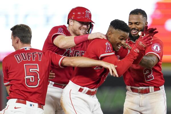 Los Angeles Angels' Magneuris Sierra, center, celebrates with Matt Duffy (5), Chad Wallach, second from left, and Luis Rengifo (2) after hitting a single on a bunt, causing Andrew Velazquez to score during the tenth inning of a baseball game against the Detroit Tigers in Anaheim, Calif., Tuesday, Sept. 6, 2022. The Angels won 5-4. (AP Photo/Ashley Landis)
