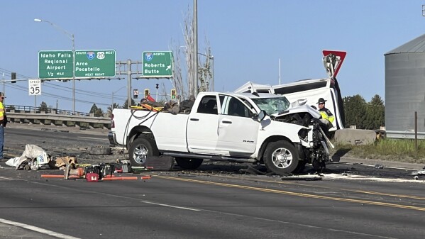 In this photo provided by KIFI Local News 8, a pickup truck crashed into a passenger van on U.S. Highway 20, Saturday, May 18, 2024, in Idaho Falls, Idaho. State police say the accident happened early Saturday morning when a pickup crossed the centerline on U.S. Highway 20 and fatally hit a passenger van. (Jeff Roper/KIFI Local News 8 via AP)