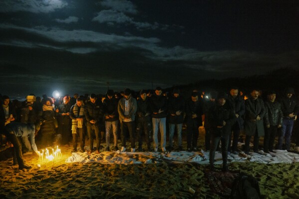 Survivors and relatives of the victims pray, Monday, Feb. 26, 2024, at the site where a migrant boat capsized in the early morning of Sunday, Feb. 26, 2023, at a short distance from the shore in Steccato di Cutro, in the Italian southern tip, killing at least 94 people. Survivors and family members of the victims gathered at the same time on the day of the disaster for a commemoration on the first anniversary. (APPhoto/Valeria Ferraro)