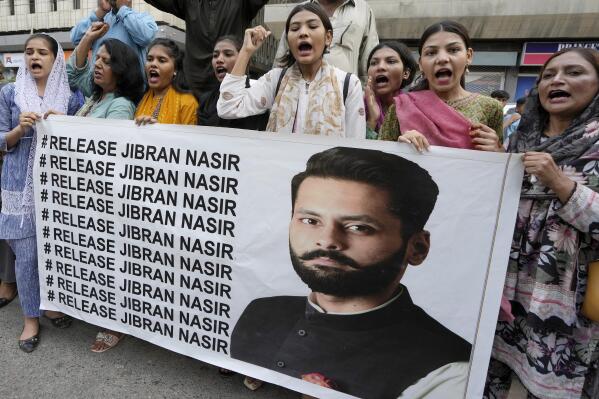 Members of a civil society group hold a banner with the picture of Pakistani human rights lawyer Jibran Nasir during a demonstration to condemn his abduction, in Karachi, Pakistan, Friday, June 2, 2023. Nasir is missing after more than a dozen armed men snatched him from his car n Thursday evening, his family said. (AP Photo/Fareed Khan)