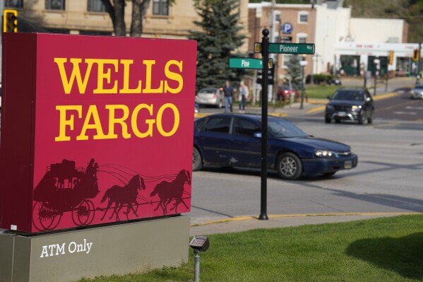 Motorists drive past a sign outside a branch of Wells Fargo bank, Wednesday, Sept. 20, 2023, in Deadwood, S.D. The Biden Administration is easing its restrictions on banking giant Wells Fargo, saying the bank has sufficiently fixed its toxic culture after years of scandals. The news sent Wells Fargo's stock up sharply in afternoon trading as investors speculated that the bank, which has been kept under a tight leash by regulators for years, may be able to start growing again. (AP Photo/David Zalubowski, File)