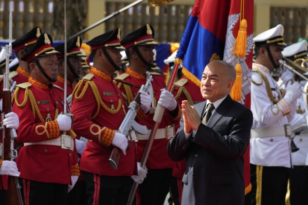 Cambodia's King Norodom Sihamoni, foreground, greets as he heads back to Royal Palace, in front of the National Assembly in Phnom Penh, Cambodia, Monday, Aug. 21, 2023. Cambodian king on Monday presided over the opening of the first session of National Assembly in Phnom Penh. (AP Photo/Heng Sinith)