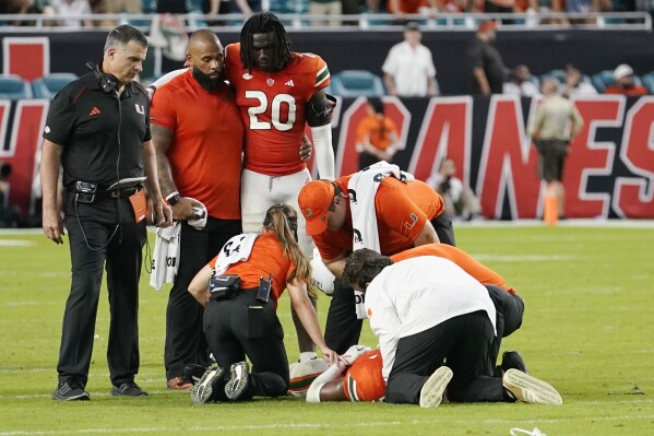 Miami head coach Mario Cristobal, left, stands by as safety Kamren Kinchens lies on the field after an injury during the second half of an NCAA college football game Saturday against Texas A&M, Sept. 9, 2023, in Miami Gardens, Fla. (AP Photo/Lynne Sladky)
