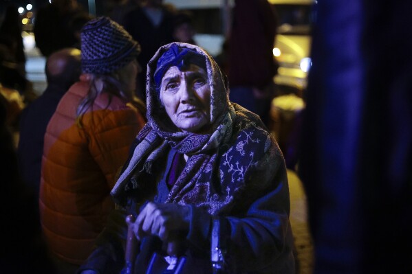 An ethnic Armenian woman from Nagorno-Karabakh stands near a tent camp after arriving to Armenia's Goris in Syunik region, Armenia, late Friday, Sept. 29, 2023. Armenian officials say that by Friday evening over 97,700 people had left Nagorno-Karabakh. The region's population was around 120,000 before the exodus began. (AP Photo/Vasily Krestyaninov)