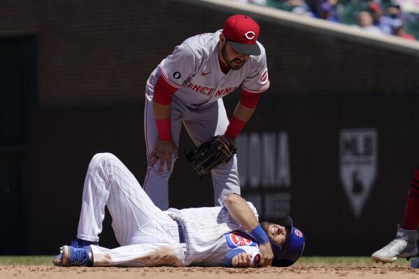 Cincinnati Reds shortstop Eugenio Suarez, top, looks down at Chicago Cubs' David Bote after an injury during the fourth inning of a baseball game in Chicago, Saturday, May 29, 2021. (AP Photo/Nam Y. Huh)