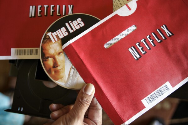 File - Mei Michelson prepares to watch a Netflix DVD at her home in Palo Alto, Calif., on Oct. 22, 2007. The Netflix DVD-by-service will mail out its final discs Friday from its five remaining distribution centers, ending its 25-year history. (AP Photo/Paul Sakuma, File)