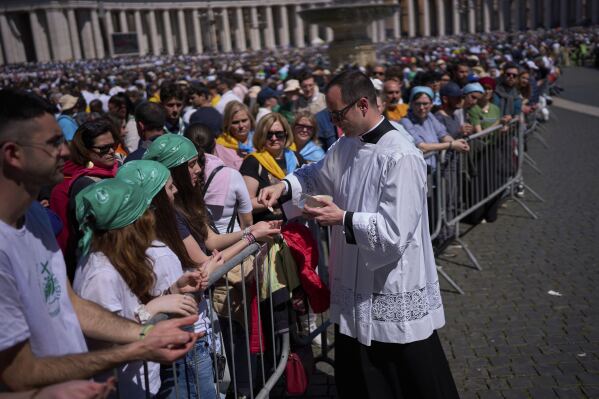 Faithful receive communion during the funeral of Pope Francis in St. Peter's Square at the Vatican, Saturday, April 26, 2025. (AP Photo/Emilio Morenatti)