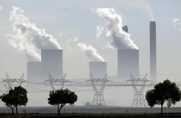 FILE - Steam billows from the chimneys at the coal-fired Lethabo power station in Vereeniging, South Africa, on Dec. 5, 2018. South Africa may delay shutting down many of its highly polluting coal-fired power stations, President Cyril Ramaphosa said Monday, April 24, 2023, a move that could stem a crisis of daily electricity blackouts but would slow a shift to greener energy sources. (AP Photo/Themba Hadebe, File)