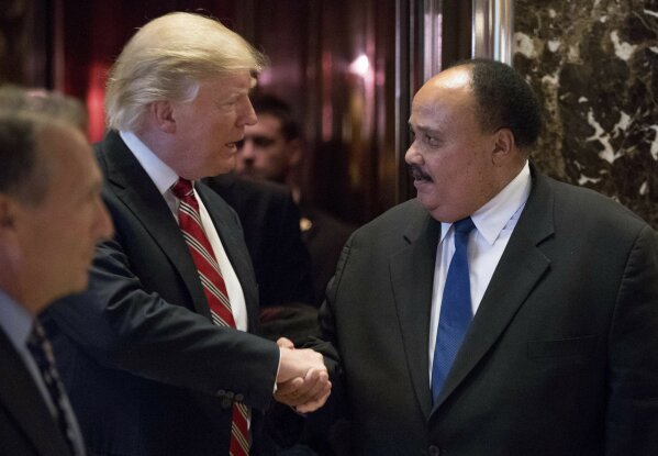 
              FILE- In this Jan. 16, 2017 file photo, President-elect Donald Trump shakes hands with Martin Luther King III, son of Martin Luther King Jr. at Trump Tower in New York. King III, met with Trump on the last King holiday, four days before Trump took office. He spoke to the then-president-elect about the importance of voting rights — only to see Trump establish a now-defunct commission to investigate voter fraud, which some saw as a move to intimidate minority voters. "I would like to believe that the president's intentions are not to be divisive, but much of what he says seems or feels to be divisive," King III told AP in an interview. "It would be wonderful to have a president who talked about bringing America together and exhibited that, who was involved in doing a social project ... that would show humility." (AP Photo/Andrew Harnik, File)
            