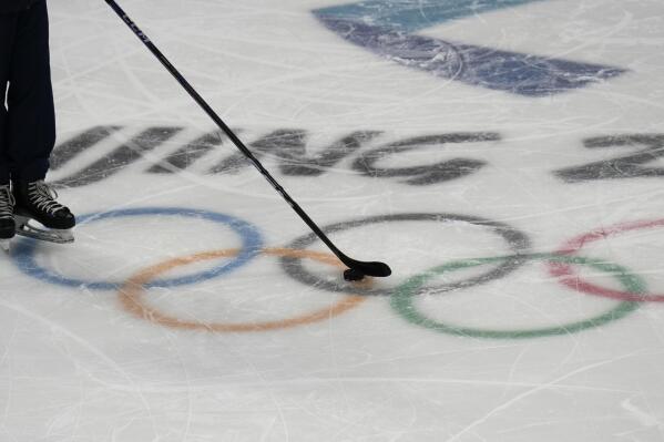 A puck slides over the Olympic rings during a hockey practice at the 2022 Winter Olympics, Wednesday, Feb. 2, 2022, in Beijing. (AP Photo/Petr David Josek)