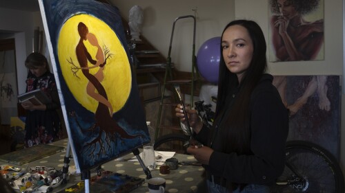 Iryna Farion, whose husband Oleksandr Alimov, a soldier, was killed in a battle with tRussian troops, paints a picture in an art studio in Kyiv, Ukraine, Saturday, June 3, 2023. For some Ukrainian women, painting has become a form of therapy to help them cope with the loss of their partners who died in the war. In a sunlit art studio in Kyiv, they create artworks depicting their grief. (AP Photo/Efrem Lukatsky)