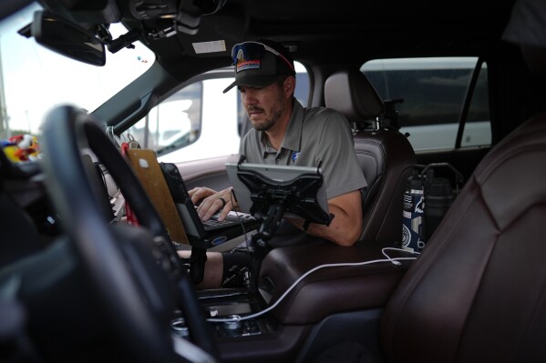 Victor Gensini, Northern Illinois University meteorology professor and a lead scientist of Project ICECHIP, works on a laptop in the command vehicle as members of Project ICECHIP stage at a Valero gas station Thursday, June 5, 2025, in Brownfield, Texas. (AP Photo/Carolyn Kaster)