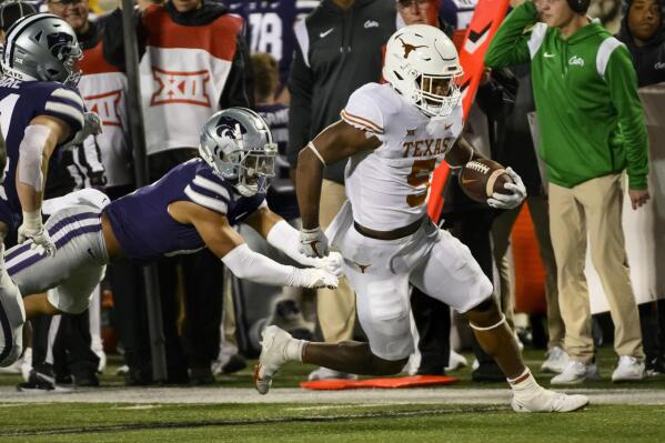 Texas running back Bijan Robinson (5) escapes a tackle by Kansas State safety Kobe Savage (2) during the first half of an NCAA college football game Saturday, Nov. 5, 2022, in Manhattan, Kan. (AP Photo/Reed Hoffmann)