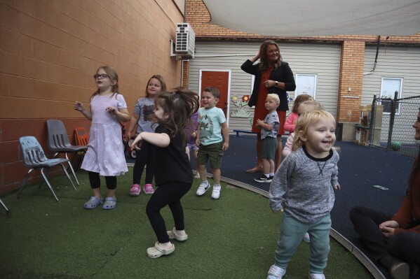 Toddlers dance during play time at Living Water Child Care and Learning Center as center director Jackie Branch looks on in Williamson, W.Va. on Monday, Sept. 25, 2023. (AP Photo/Leah Willingham)