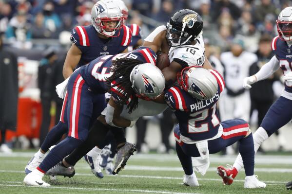 Jacksonville Jaguars wide receiver Laquon Treadwell (18) is taken down by New England Patriots safety Kyle Dugger, left, and defensive back Adrian Phillips, right, during the first half of an NFL football game, Sunday, Jan. 2, 2022, in Foxborough, Mass. (AP Photo/Paul Connors)