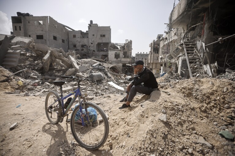 A Palestinian sits among destruction after Israeli forces left Khan Younis, Gaza Strip, Wednesday, March 6, 2024. (AP Photo/Mohammed Dahman)