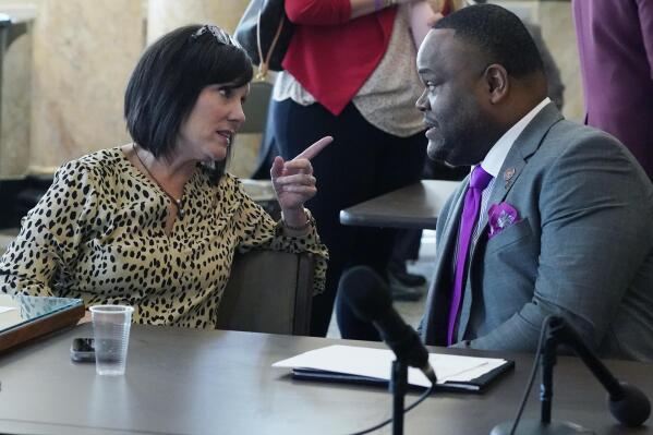 House Medicaid Committee member Missy McGee, R-Hattiesburg, left, confers with Rep. Otis Anthony, D-Indianola, Tuesday, Feb. 28, 2023, at the Mississippi Capitol in Jackson, after the committee passed legislation that would extend postpartum Medicaid coverage from two months to a year. (AP Photo/Rogelio V. Solis)