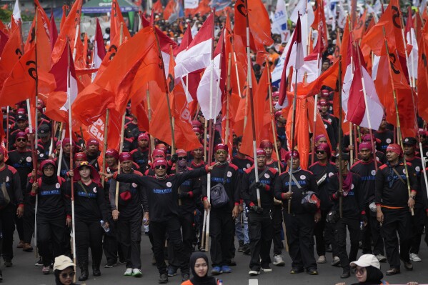 Trabalhadores marcham durante um desfile do Primeiro de Maio em Jacarta, Indonésia, quarta-feira, 1 de maio de 2024. Milhares de trabalhadores instaram o governo a aumentar o salário mínimo e a melhorar as condições de trabalho.  (Foto AP/Ahmed Ibrahim)