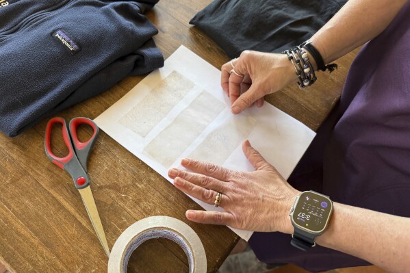 Rachael Z. Miller, founder of the Vermont-based Rozalia Project for a Clean Ocean, conducts a tape test on various clothing items to compare how much each material sheds microfibers on Thursday, April 17, 2025, in Granville, Vt. (AP Photo/Amanda Swinhart)