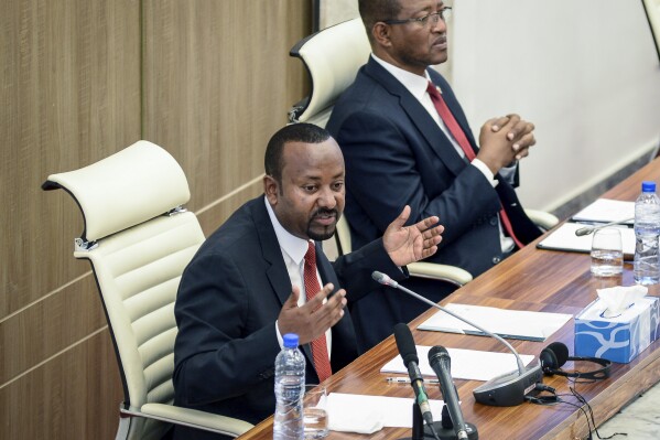 FILE - Ethiopia's Prime Minister Abiy Ahmed, left, accompanied by House speaker Tagesse Chafo, right, addresses the parliament in the capital Addis Ababa, Ethiopia on Nov. 15, 2022. Authorities in Ethiopia are carrying out mass arrests of hundreds, even thousands, of people in the capital after deadly unrest in the country’s Amhara region, lawyers and witnesses said. Ethiopia’s parliament is to vote Monday Aug. 14, 2023 on giving formal approval to extraordinary measures which allow authorities to arrest suspects without a warrant, conduct searches and impose curfews. (AP Photo/File)