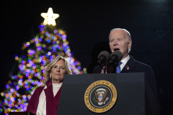 President Joe Biden speaks as first lady Jill Biden listen after they lit the National Christmas Tree on the Ellipse, near the White House, Thursday, Nov. 30, 2023, in Washington. (AP Photo/Andrew Harnik)
