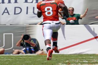 FILE - University of Miami's Duke Johnson scores a touchdown on a kick off return in first quarter as fans cheer as they play Bethune-Cookman's at Sun Life Stadium in Miami Gardens, Florida, Sept. 15, 2012. Johnson grew up practically in the shadow of Hard Rock Stadium, attending high school just a few minutes from the Miami Dolphins’ field. It was his home field in college, with the Miami Hurricanes playing there. And he’s hoping to play there again Sunday, Nov. 28, 2021, when his new team — the Dolphins — host the Carolina Panthers. (Charles Trainor Jr/Miami Herald via AP)