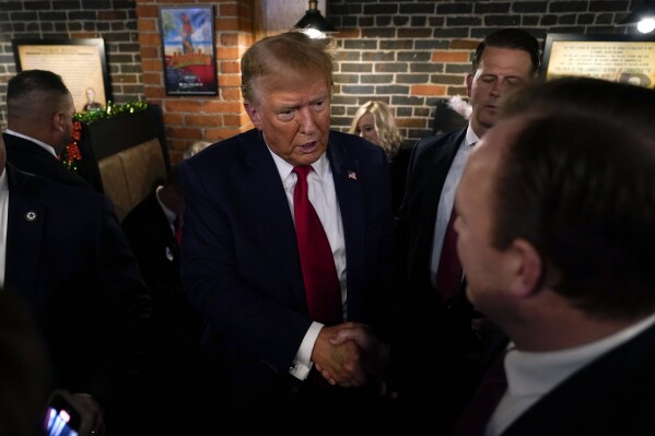 Former President Donald Trump greets supporters during a stop at the Front Street Pub & Eatery, Tuesday, Dec. 5, 2023, in Davenport, Iowa. (AP Photo/Charlie Neibergall)