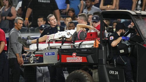 A camera operator who was injured on a throwing error by Baltimore Orioles' Gunnar Henderson has ben placed on a cart during the fifth inning of the Orioles' baseball game against the New York Yankees on Wednesday, July 5, 2023, in New York. (AP Photo/Frank Franklin II)