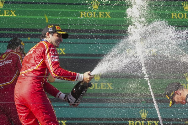 Ferrari driver Carlos Sainz of Spain sprays champagne as he celebrates after winning the Australian Formula One Grand Prix at Albert Park, in Melbourne, Australia, Sunday, March 24, 2024. (AP Photo/Scott Barbour)