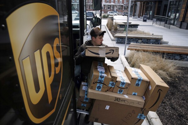 FILE - A UPS driver prepares to deliver packages in Baltimore, Md., Dec. 19, 2018. UPS plans to hire more than 100,000 workers _ at higher pay than a year ago _ to help handle the holiday rush this season, in line with hiring the previous three years. (AP Photo/Patrick Semansky, File)