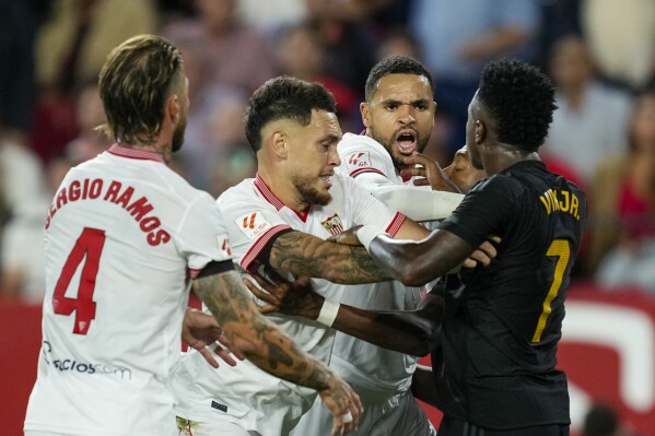 Real Madrid's Vinicius Junior, right, argues with Sevilla players during a Spanish La Liga soccer match between Sevilla and Real Madrid, at the Ramon Sanchez Pizjuan stadium in Seville, Spain, Saturday, Oct. 21, 2023. (AP Photo/Jose Breton)