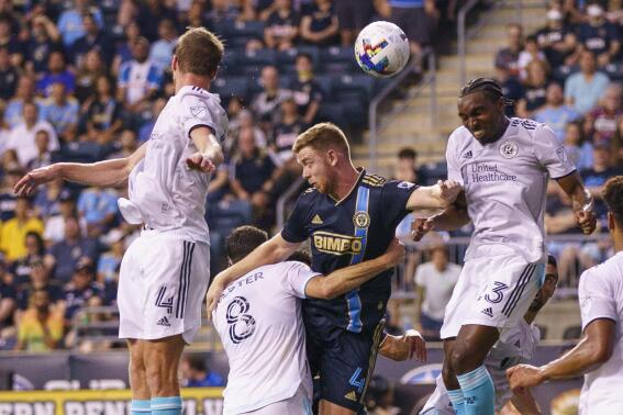 New England Revolution's Jonathan Bell, right, heads the ball away from Philadelphia Union's Stuart Findlay, center right, during the first half of an MLS soccer match Saturday, July 16, 2022, in Chester, Pa. (AP Photo/Chris Szagola)