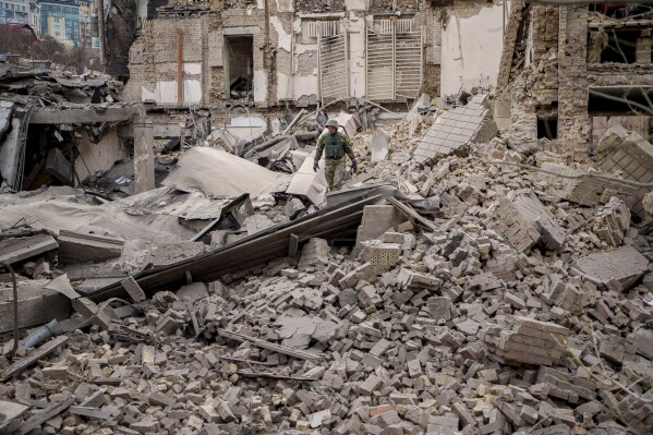 A Ukrainian serviceman inspects the damage to a building at the Pecherskyi district, after a Russian air attack in Kyiv, Ukraine, Monday March 25, 2024. Five people were injured in the strike, two were hospitalized. (AP Photo/Vadim Ghirda)