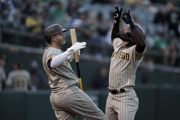 San Diego Padres' Fernando Tatis Jr., right, celebrates with Manny Machado after hitting a solo home run against the Oakland Athletics during the first inning of a baseball game Friday, Sept. 15, 2023, in Oakland, Calif. (AP Photo/Godofredo A. Vásquez)