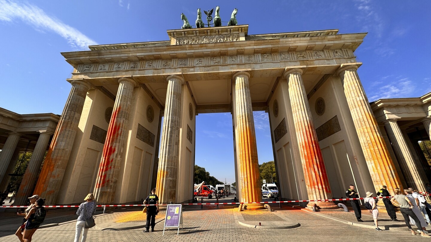 Klimaaktivisten besprühen das Berliner Brandenburger Tor mit oranger Farbe