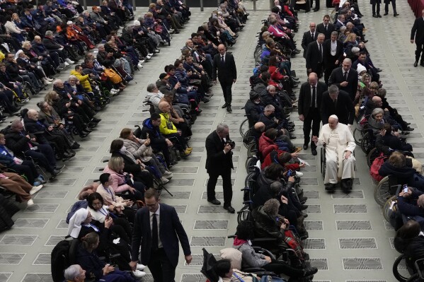 Pope Francis leaves after an audience with sick people and Lourdes pilgrimage operators in the Paul VI Hall, at the Vatican, Thursday, Dec. 14, 2023. (AP Photo/Alessandra Tarantino)